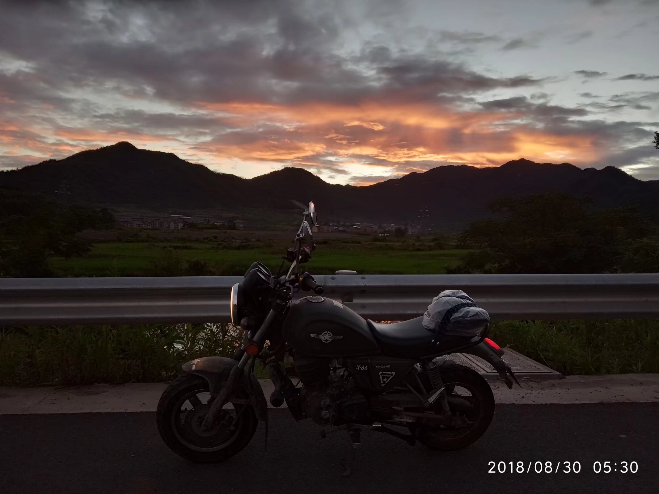 朝霞中的摩托车